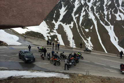 Sonnleiten 20 Timmelsjoch, Jaufenpass, Kühtai Motorradfahrer und Auto an einem Bergpass mit Schnee auf den Bergen