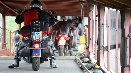 Motorradfahrer mit rotem Rucksack auf Fähre mit anderen Motorradfahrern