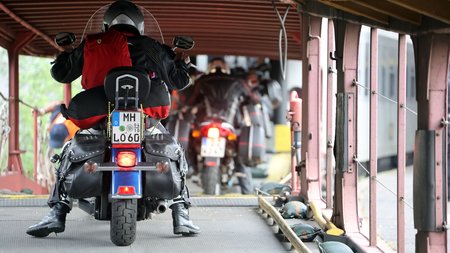 Motorrad- und Autoreisezug © Eduard Bopp Motorradfahrer mit rotem Rucksack auf Fähre mit anderen Motorradfahrern