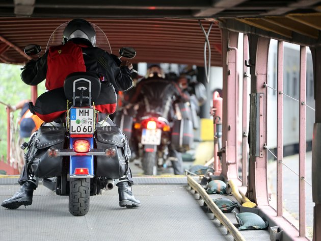 Motorrad- und Autoreisezug © Eduard Bopp Motorradfahrer mit rotem Rucksack auf Fähre mit anderen Motorradfahrern