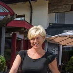 Zwei Personen mit alten und modernen Motorrädern vor einem Hotel