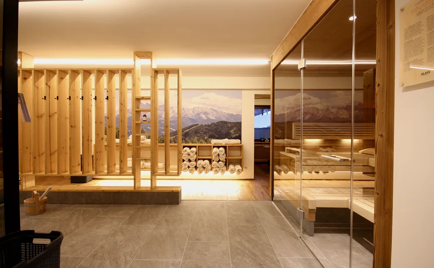 Modern sauna area with wooden elements and rolled towels