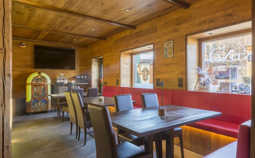Hotel La Stüa **** © Hotel La Stüa Gemütlicher Essbereich mit Holzwänden, roten Sitzbänken und Jukebox
