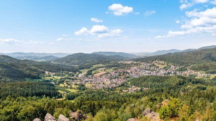 Bayerischer Wald © Bodenmais Panoramablick auf eine Stadt im Tal umgeben von bewaldeten Bergen und blauem Himmel