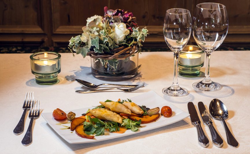 Elegante Tischdekoration mit Vorspeise, Blumen und Kerzenlicht