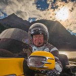Motorradurlaub in Tirol © Moppetfoto.de Mann auf gelbem Motorrad vor Berglandschaft bei Sonnenuntergang