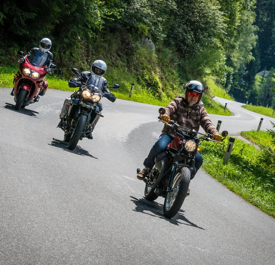 Motorvakanties in Neder-Oostenrijk © Moppetfoto.de Drie motorfietsen rijden op een kronkelende bergweg door het bos