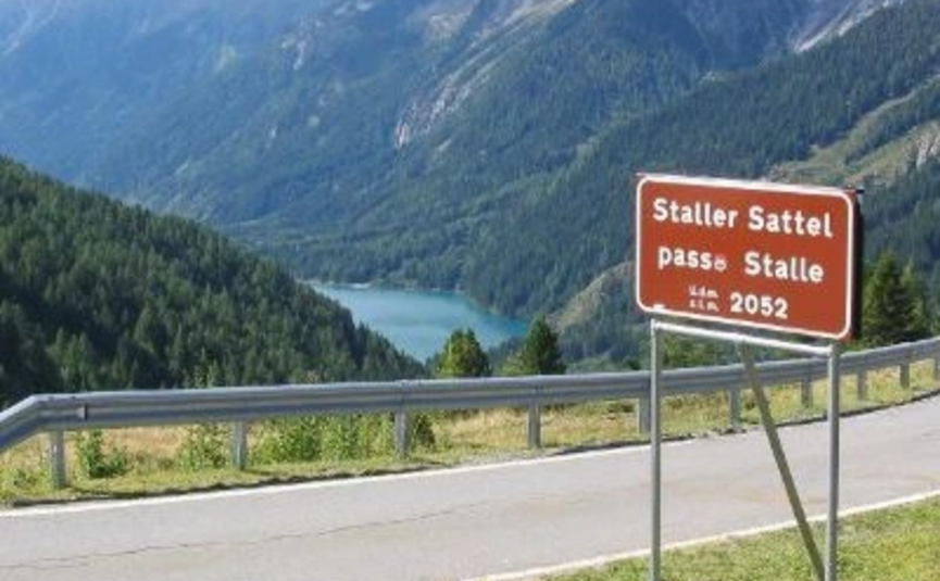 Straßenschild Staller Sattel Passhöhe 2052 Meter mit Bergsee im Hintergrund