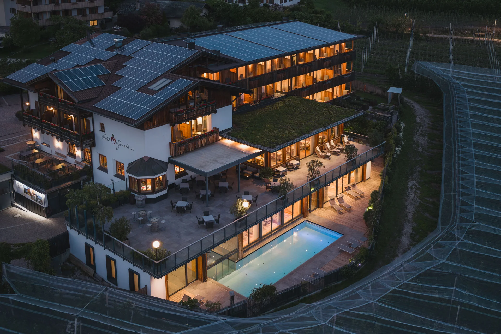 Motorradurlaub © Upscale Hotel mit Solarpanelen auf dem Dach und beleuchtetem Pool bei Nacht