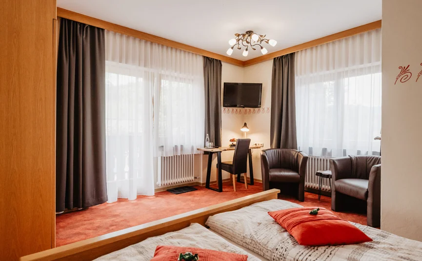 Cozy hotel room with two beds, desk, and seating area