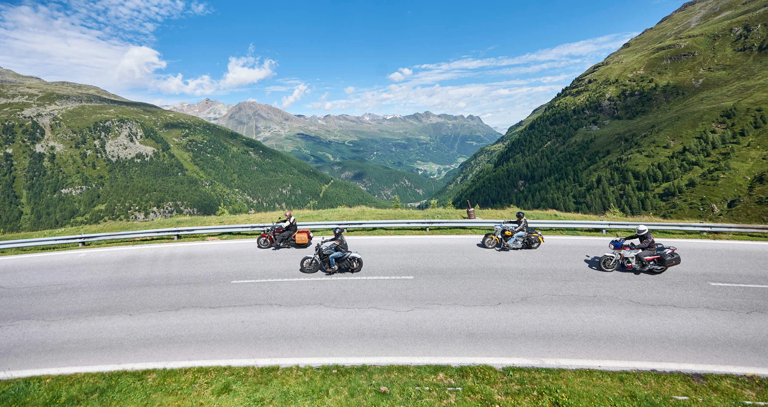 Italië © studio22.at - Marcel Hagen Vier motorfietsen op kronkelende bergweg met Alpenlandschap