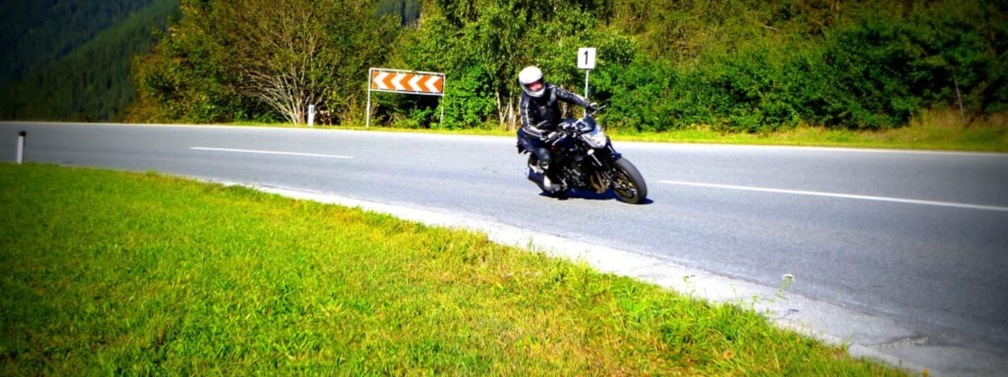 Motorradpauschale Motorrijder op een bochtige bergweg op een zonnige dag