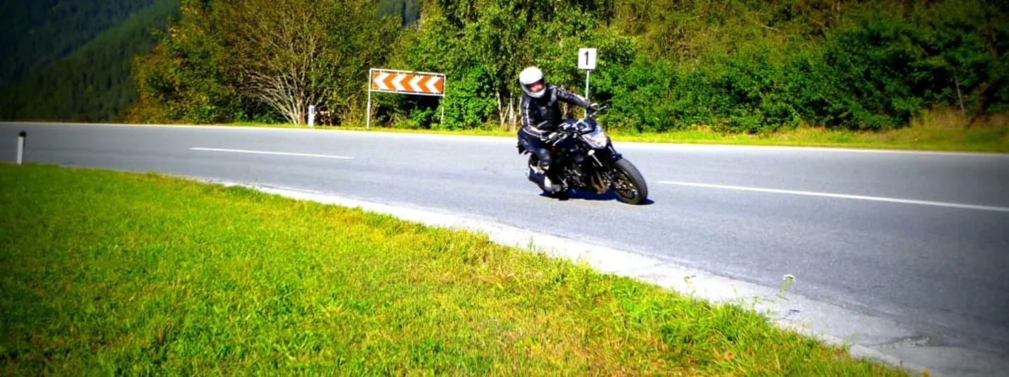 Motorradpauschale Motorrijder op een bochtige bergweg op een zonnige dag