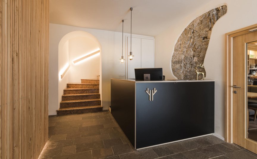 Moderne receptieruimte met zwarte balie en verlichte trap