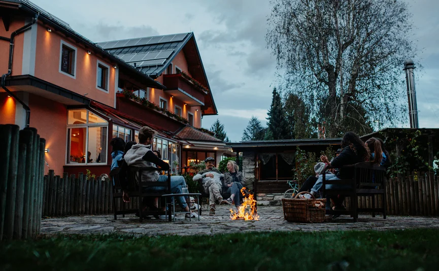 Gailtaler Hof © Niko Opetnik Group of people sitting around a fire pit in a backyard during evening
