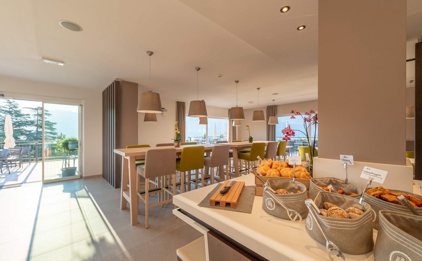 Modernes Frühstücksbuffet mit Brötchen und Sitzgelegenheiten in hellem Raum