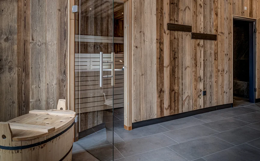 Moderner Saunaraum mit Holzwänden und Glas-Tür