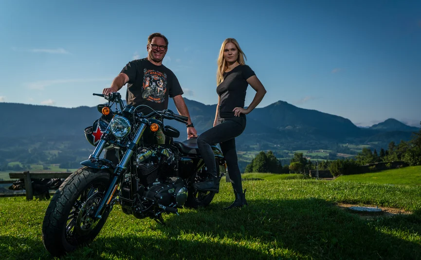 Gasthof Hotel Zur Post Samerberg *** © Moppetfoto.de Mann und Frau posieren mit einem Motorrad vor einer Berglandschaft