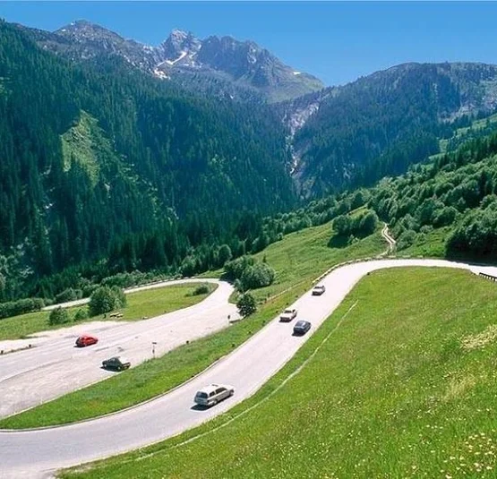Kitzbühel Hansi Tour (Gerlos - Zillertal - Kitzbühel) Winding mountain road with cars, green hills, and forested mountains