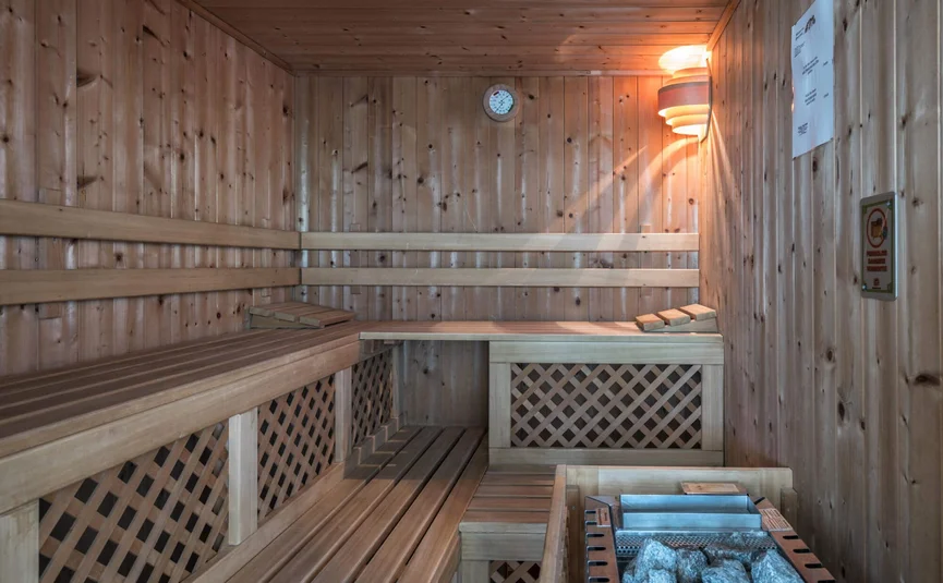 Lege houten sauna met saunakachel en warm licht