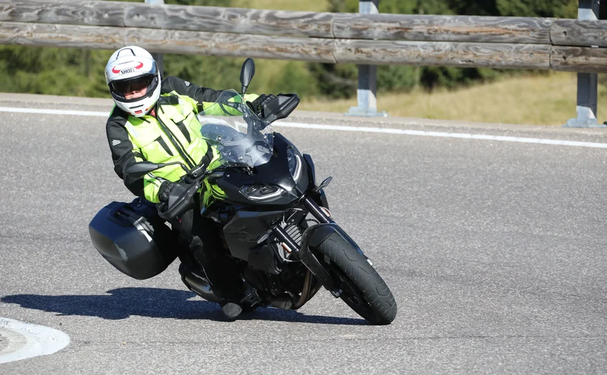 Stelvio Pass - Gavia - Mendel www.ludwigshof.it Motorcyclist wearing safety gear riding on a curved road