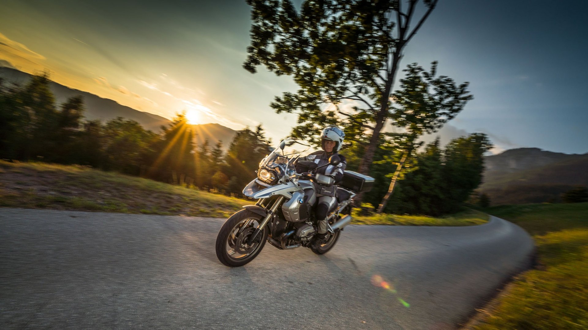 Dein Motorrad-Erlebnis © Moppetfoto.de Motorradfahrer auf kurviger Straße bei Sonnenuntergang in ländlicher Umgebung