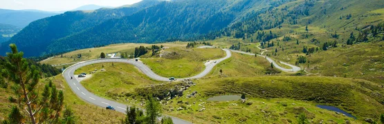 Winding mountain road with green hills and blue sky