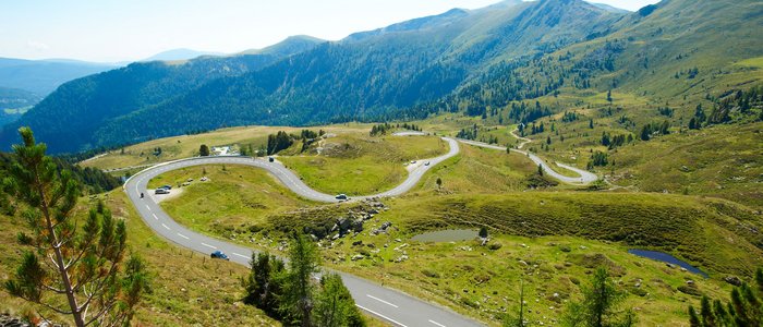 Serpentinenstraße in den grünen Bergen bei klarem Himmel