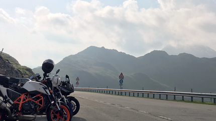 Motorräder geparkt an Bergstraße mit Bergen im Hintergrund