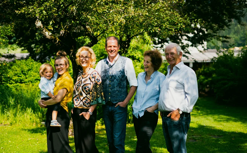 Three generations of a smiling family in the garden on a sunny day