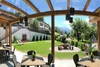 Sammelanfragen © Manuel Jäger Überdachte Terrasse mit Tischen, Stühlen und Bergblick in einem Garten