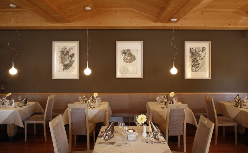 Hotel am Reschensee *** © The Dilitz Company GmbH Gemütliches Restaurant mit gedeckten Tischen und moderner Beleuchtung