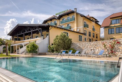 Hotel Marienhof mit Außenpool und Liegestühlen bei sonnigem Wetter