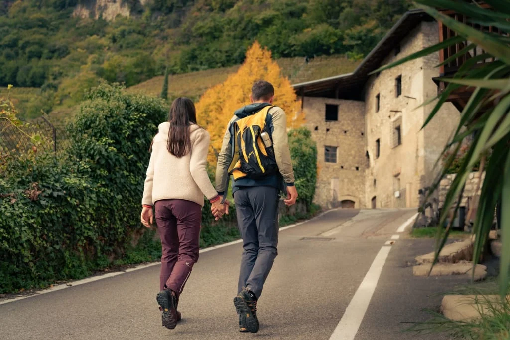 Couple walking hand in hand on a country road with autumn trees