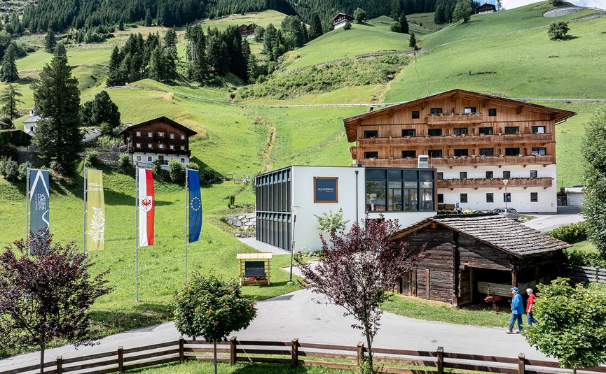 Alpenlandschap met hotel, moderne en traditionele gebouwen en groene heuvels
