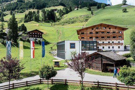 DAS UNTERRAIN lifestyle hotel © Armin Kleinlercher Alpenlandschaft mit Hotel, moderner und traditioneller Architektur und grünen Hügeln