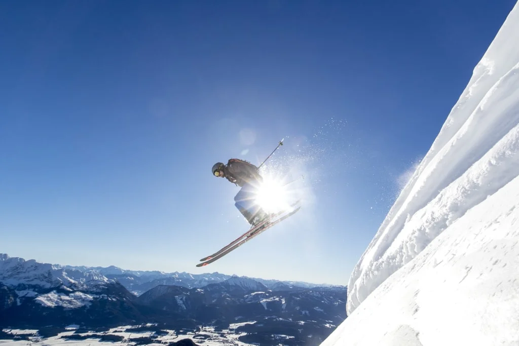 Mid week ski days 4 Skier jumping over a snowy slope against an alpine mountain landscape