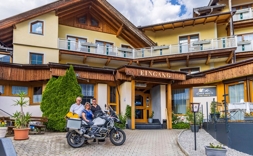 Erlebnishotel Kärnten-Mölltal ***S © Alexander Seger Drei Personen neben Motorrad vor dem Eingang eines Gasthauses