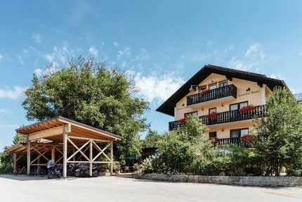 Landhotel Neuhof mit blumengeschmückten Balkonen und überdachtem Motorradstellplatz