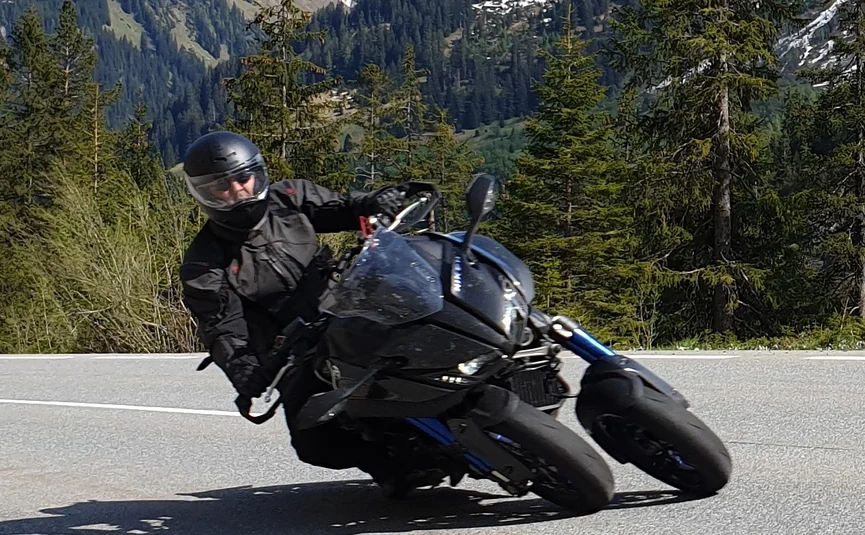 Motorradfahrer fährt in den Bergen auf kurviger Straße