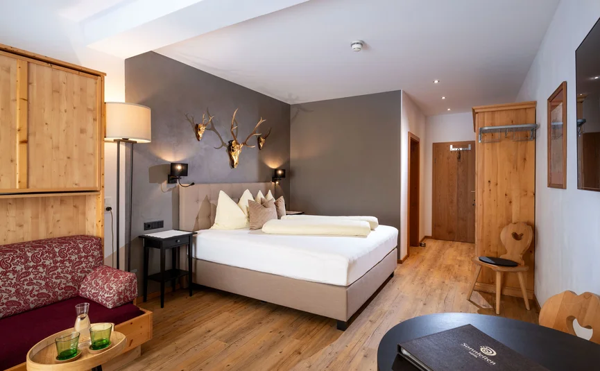 Cozy hotel room with double bed and rustic wooden decor
