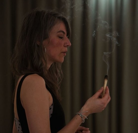 SoulSpace Retreat - Reinigen. Loslassen. Ankommen. Frau hält brennenden Räucherstick, Dunst steigt auf