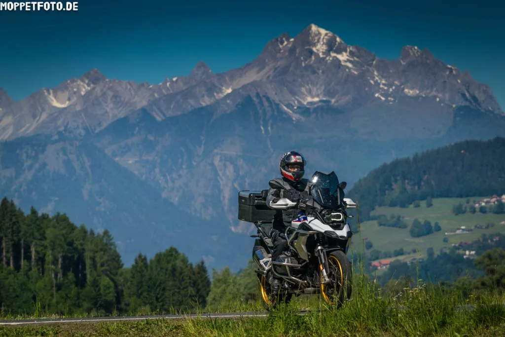 Ride & Relax Motorrijder voor berglandschap met beboste heuvels en blauwe lucht