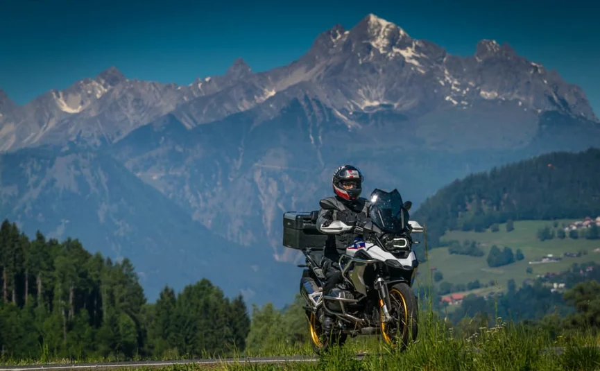 Ride & Relax Motorrijder voor berglandschap met beboste heuvels en blauwe lucht