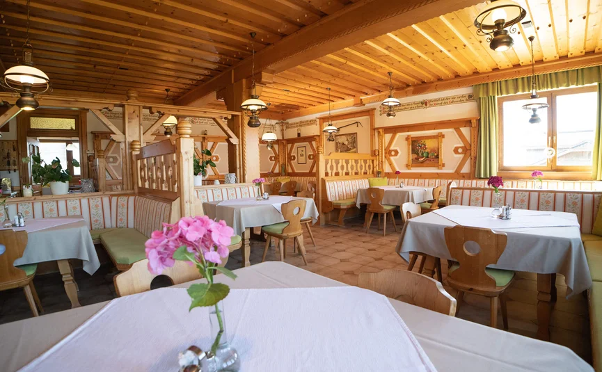 Cozy traditional restaurant interior with wooden furniture and flowers on tables