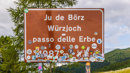 Straßenschild Passo delle Erbe mit vielen Aufklebern in den Bergen