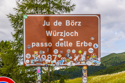 Straßenschild Passo delle Erbe mit vielen Aufklebern in den Bergen