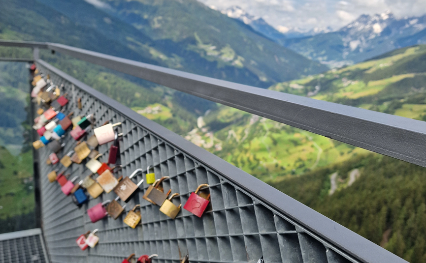 MoHo Schönauer Hof Tour 5 Kaunertal Glacier Variant 2 Love locks on metal railing with mountain landscape in the background
