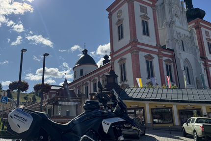 Kerzerl anzünden in Mariazell Motorrad vor historischer Kirche im Sonnenschein
