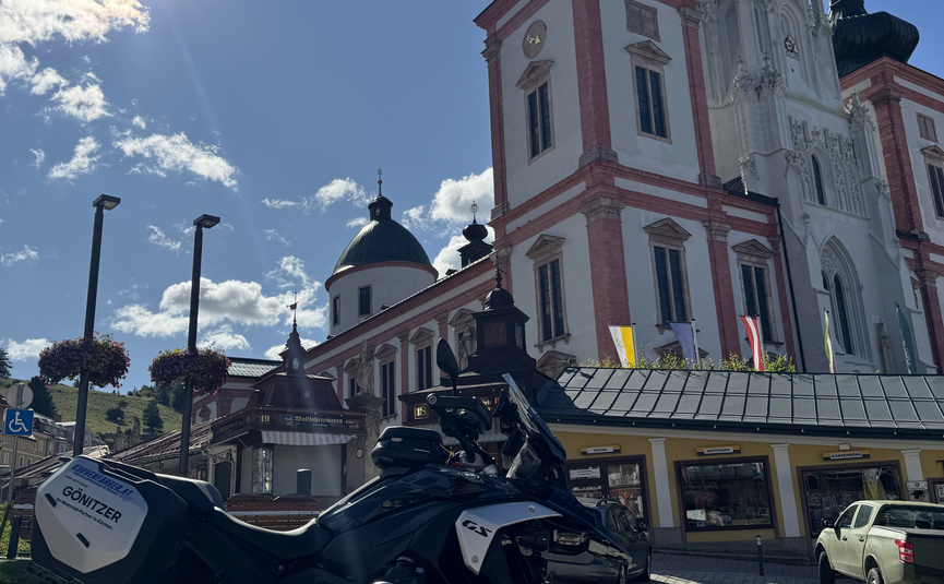 Motorrad vor historischer Kirche im Sonnenschein
